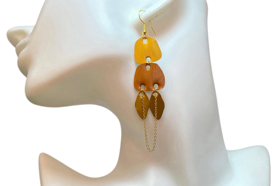 gold, copper, bronze upcycled nespresso capsules earrings on a white mannequin and white backgroun