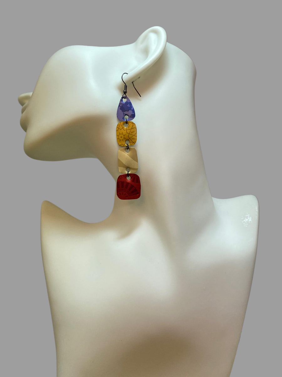 blue, brown, red, colourful earrings made from upcycled nespresso pods on awhite mannequin and grey background