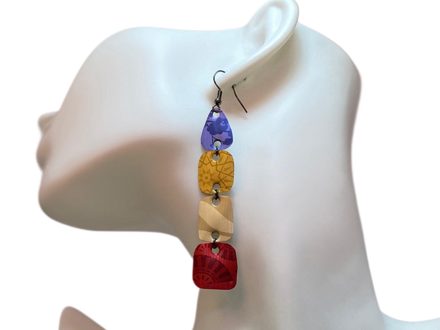 blue, brown, red, colourful earrings made from upcycled nespresso pods on awhite mannequin and background