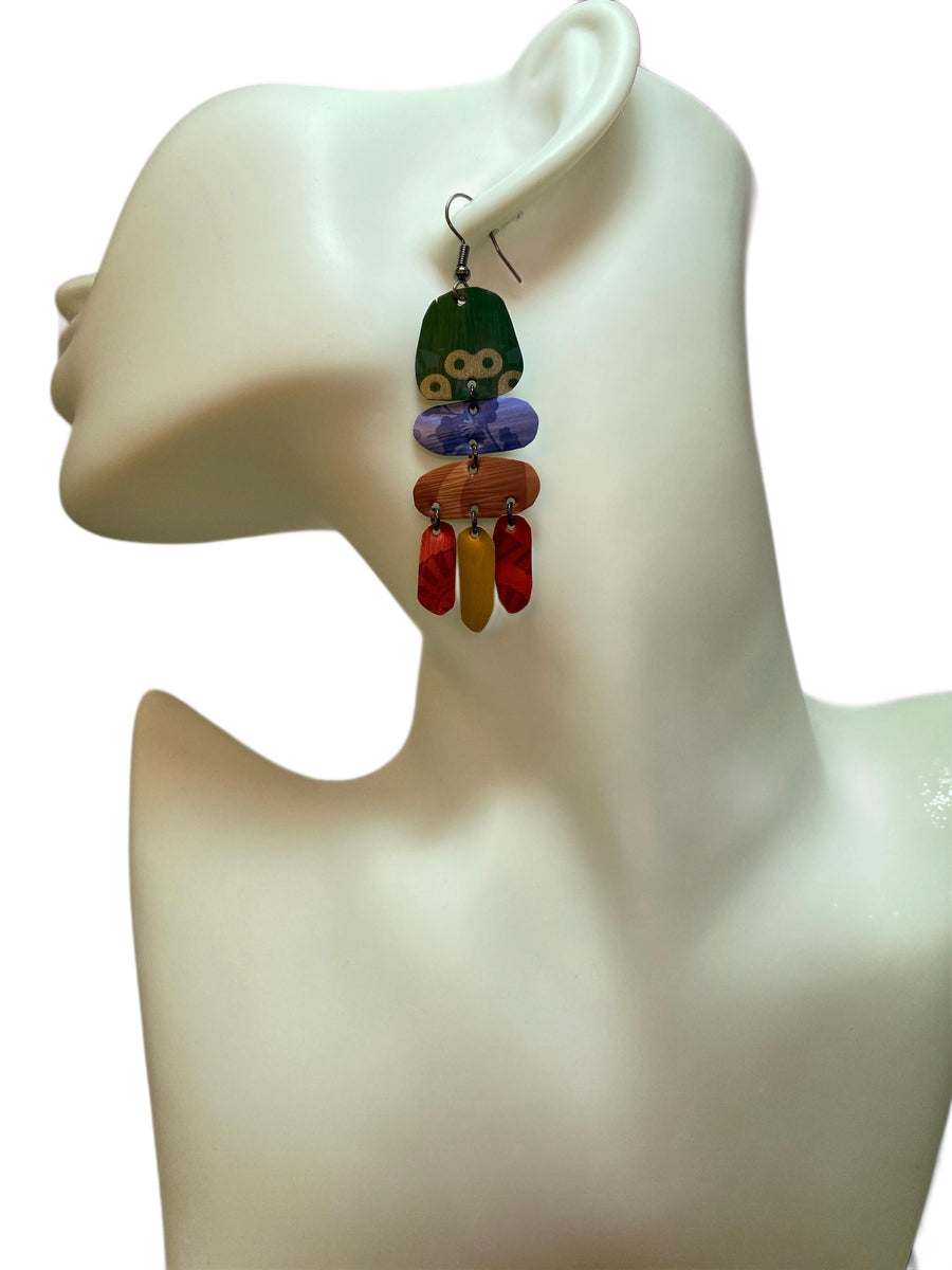 bright, colourful, green, blue, red, gold earrings made from recycled nespresso capsules on a white mannequin and white  background