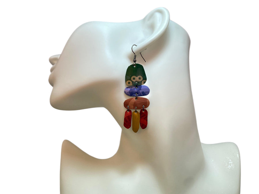 bright, colourful, green, blue, red, gold earrings made from recycled nespresso capsules on a white mannequin and white background