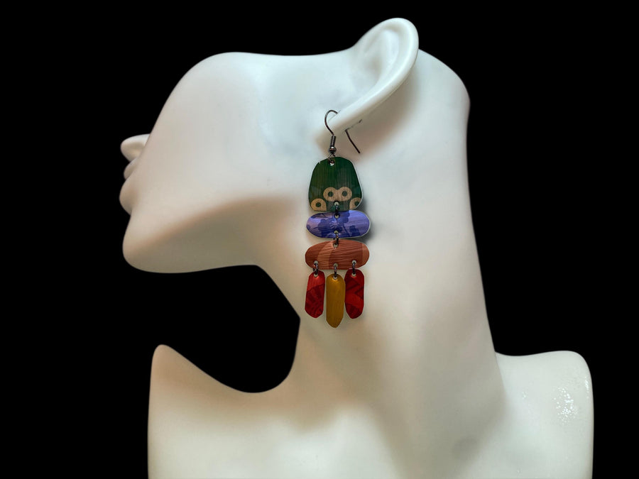 bright, colourful, green, blue, red, gold earrings made from recycled nespresso capsules on a white mannequin and black background