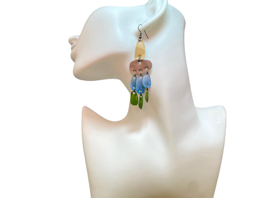 large, long, sand, blue, green earrings made from upcycled nespresso capsules on a white mannequin and white background