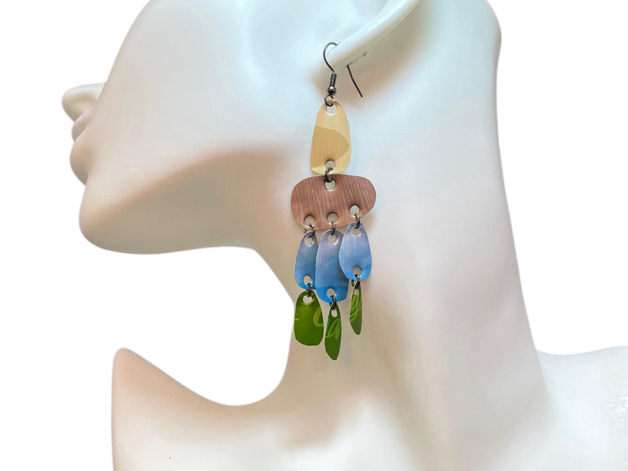 large, long, sand, blue, green earrings made from upcycled nespresso capsules on a white mannequin and white background