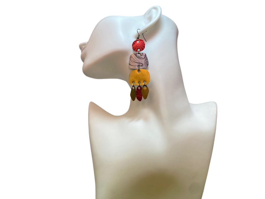 large, long, red, silver, golden earrings made from upcycled nespresso capsules on a white mannequin and background