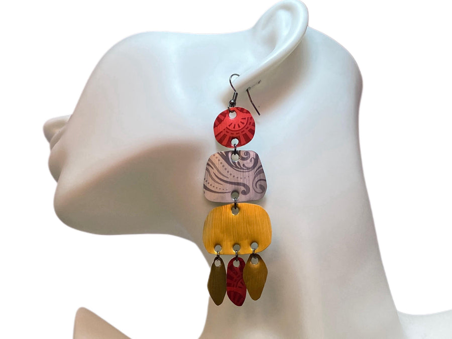 large, long, red, silver, golden earrings made from upcycled nespresso capsules on a white mannequin and background