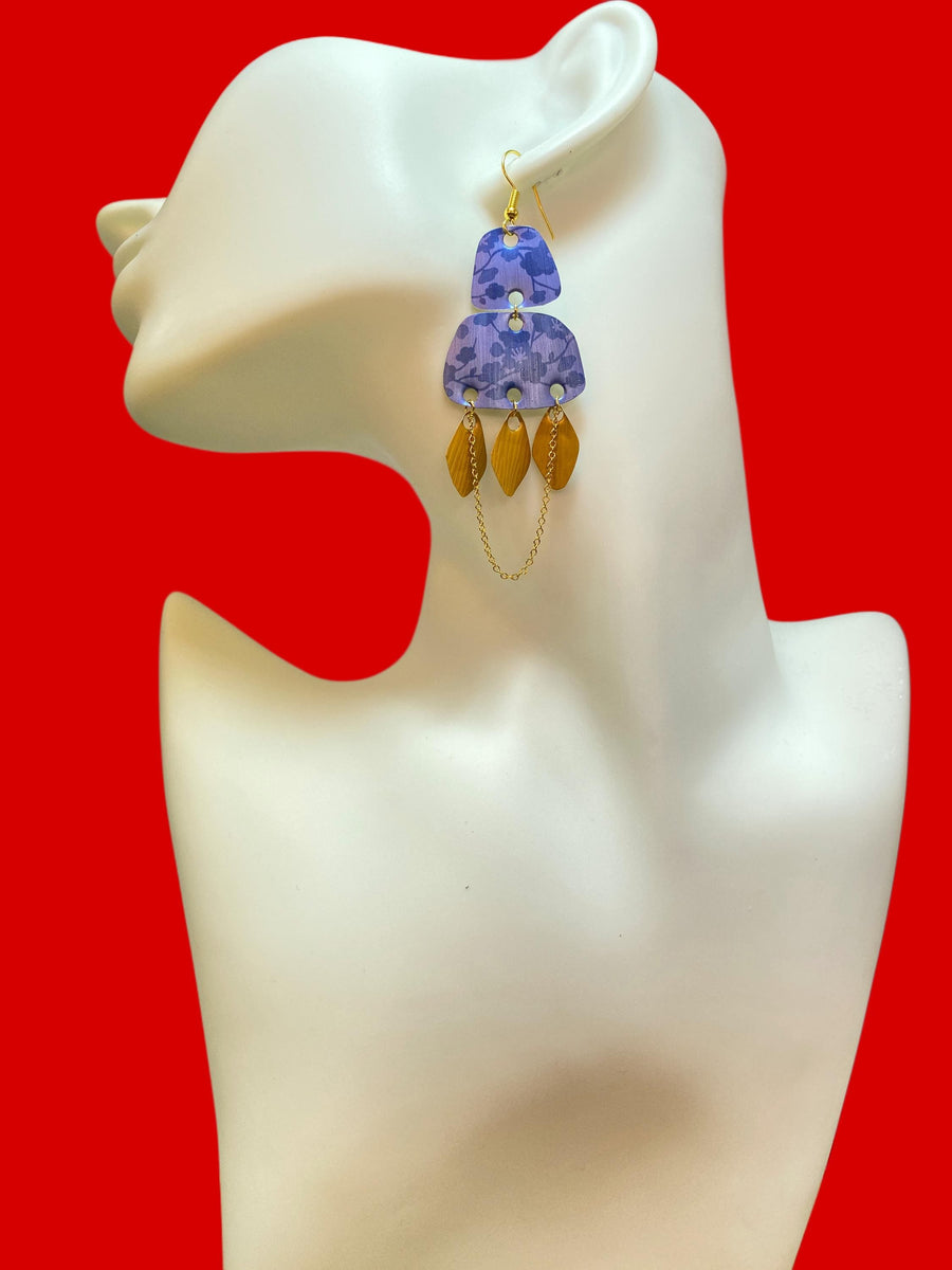 blue gold oriental, upcycled nespresso pod earrings on a white mannequin and red background