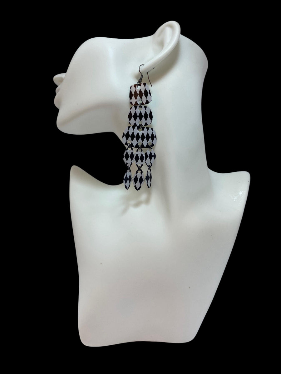 black and white upcycled chandelier earrings made from nespresso capsules on a white mannequin and black background