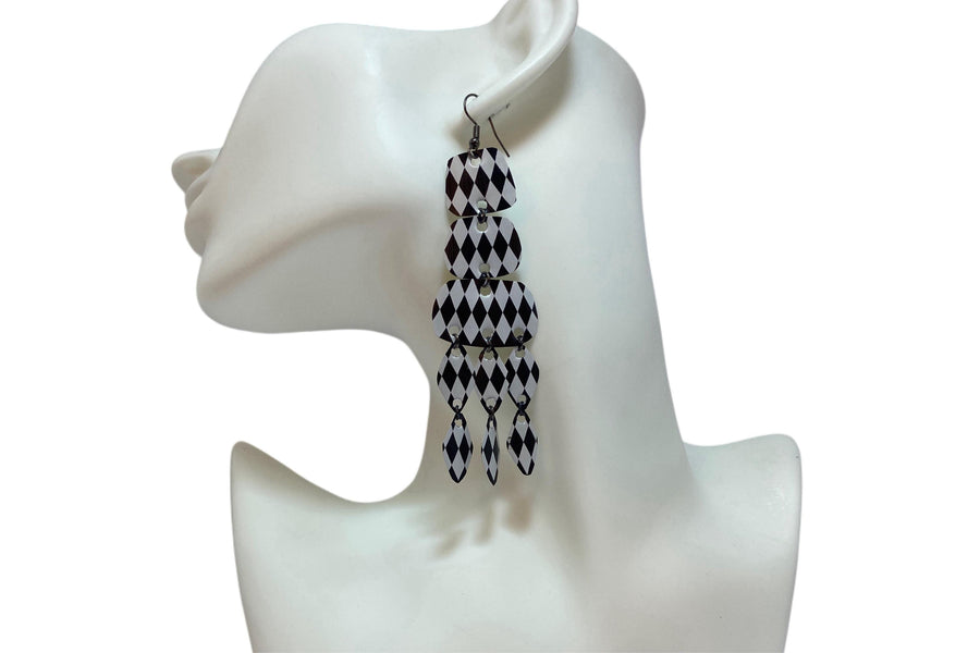 black and white upcycled chandelier earrings made from nespresso capsules on a white mannequin and background