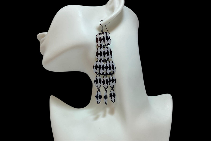 black and white upcycled chandelier earrings made from nespresso capsules on a white mannequin and black background