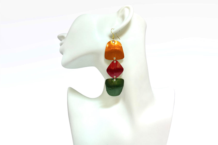 orange, red, green geometric earrings made from upcycled nespresso pods, on a white mannequin and background