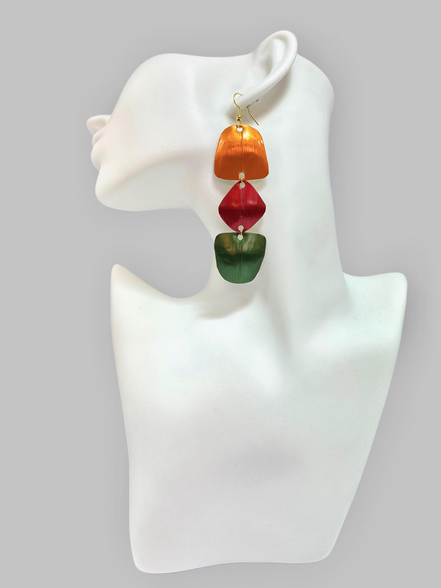 orange, red, green geometric earrings made from upcycled nespresso pods, on a white mannequin and grey background