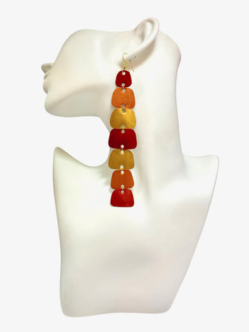 long, red, peach, gold earrings made from nespresso capsules on a white mannequin