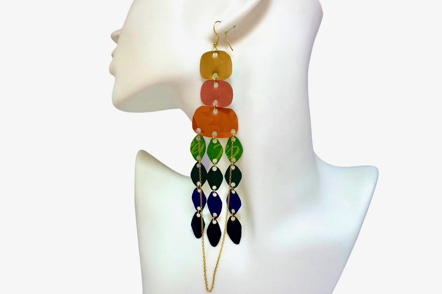 large, rainbow coloured chandelier earrings made from colourful Nespresso pods with agolden chain, on a white mannequin and white background