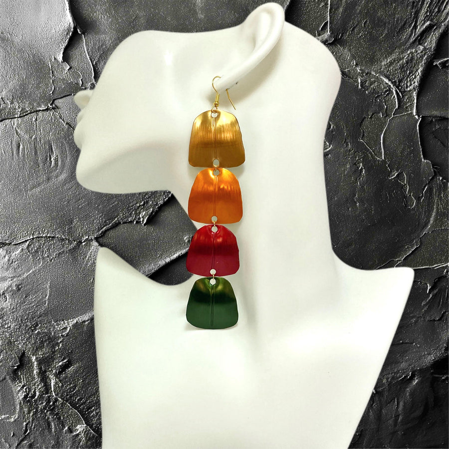 gold orange red green statement earrings made from Upcycled nespresso capsules on a white mannequin and black background