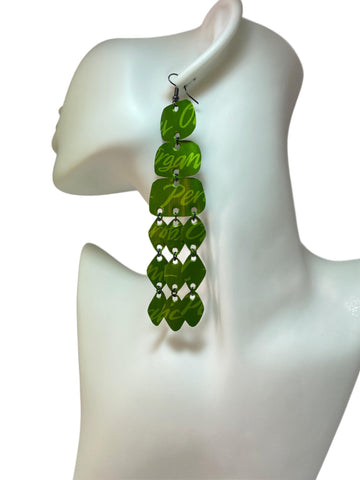 large, bold, bright green coloured chandelier earrings made from nespresso capsules on a white mannequin and background