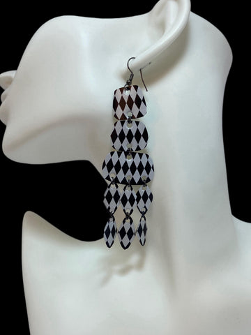 black and white upcycled chandelier earrings made from nespresso capsules on a white mannequin and black background