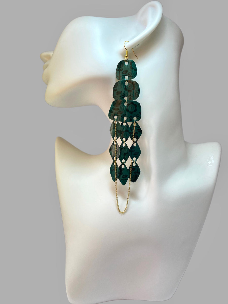 dark green long chandelier earrings made from upcycled nespresso capsules on a white mannequin and grey background