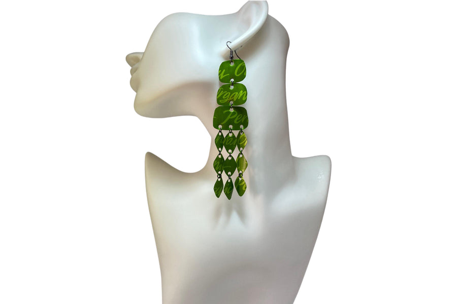 large, bold, bright green coloured chandelier earrings made from nespresso capsules on a white mannequin and background