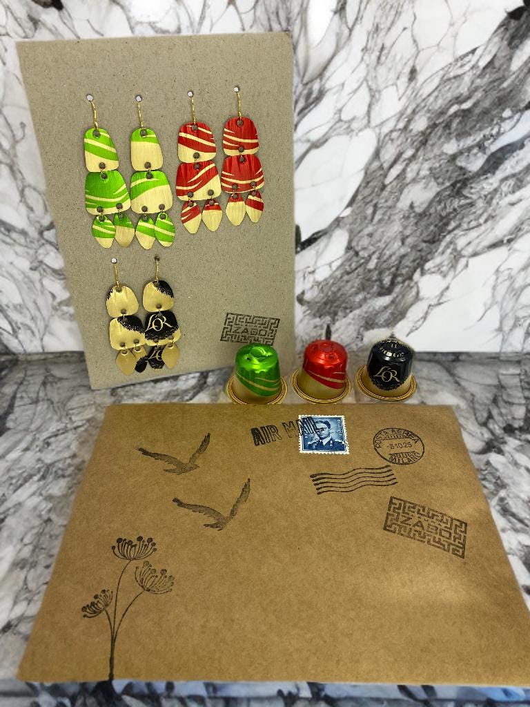 Upcycled Nespresso capsules earrings set on carton  paper display on marble kitchen desk with packaging envelope