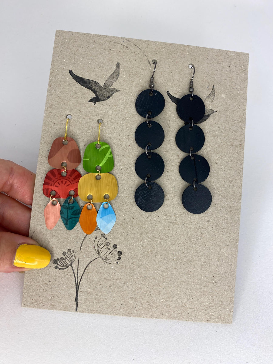 2 pairs of earrings, colourful,upcycled Nespresso capsule and bicycleinner tube earrings on a carton