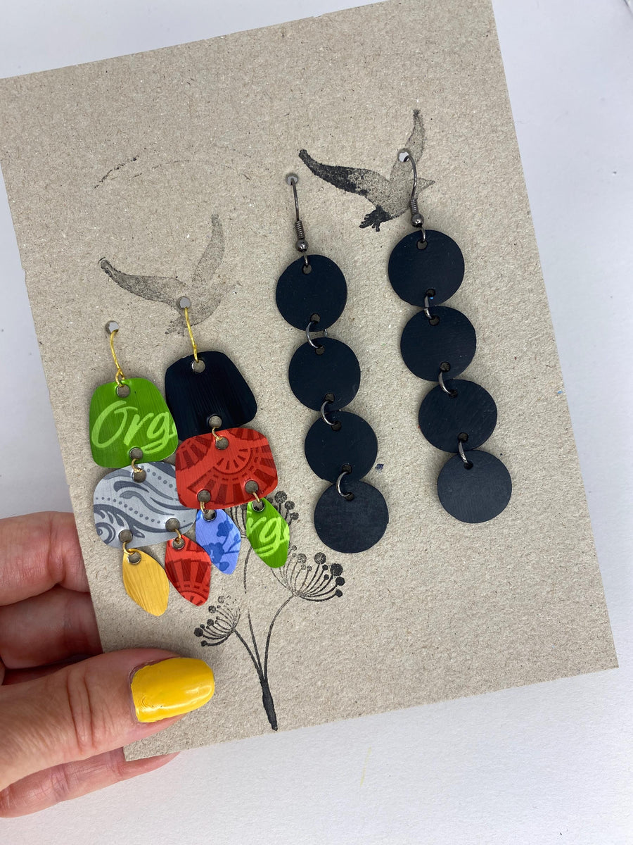 2 pairs of earrings, colourful,upcycled Nespresso capsule and bicycleinner tube earrings on a carton