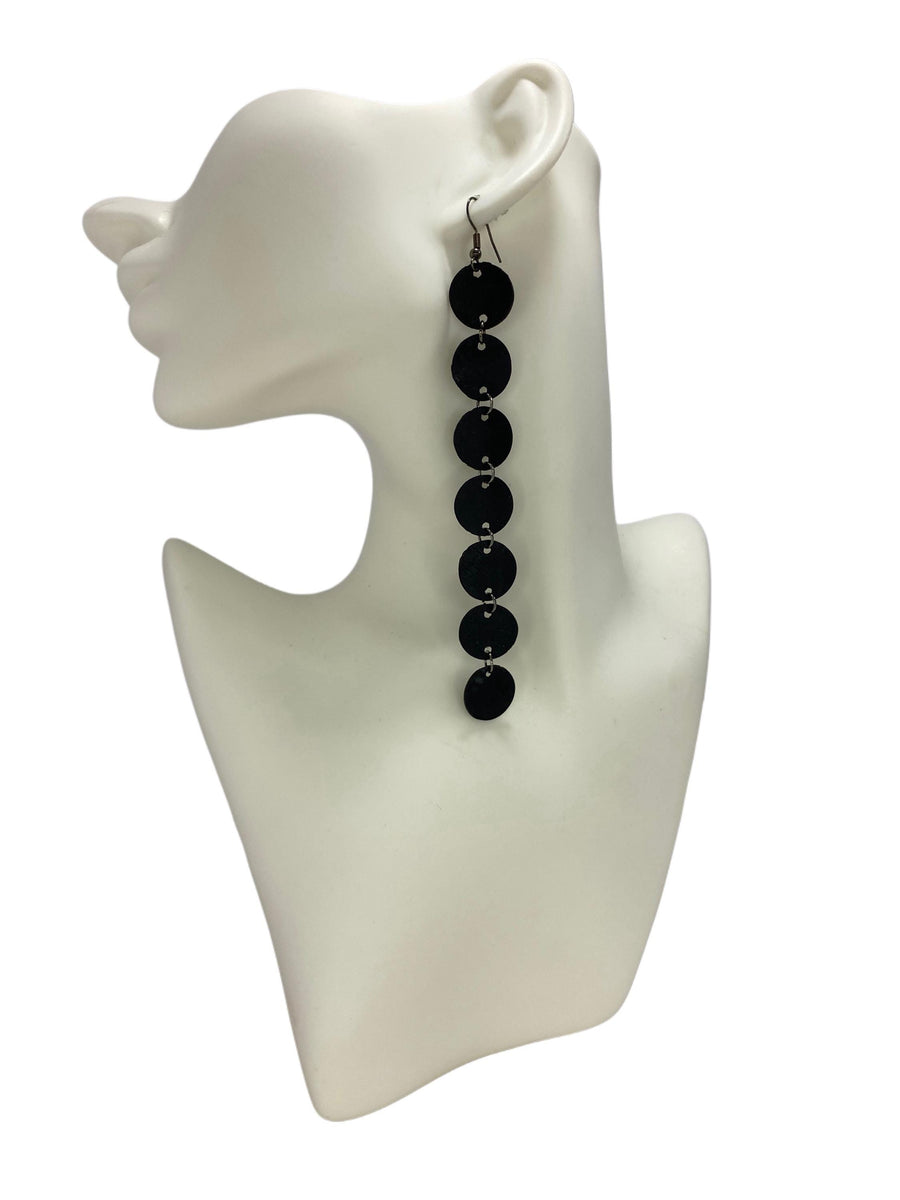 Black, long earring features  rubber discs connected with jumprings made from upcycled bicycle inner tubes, on a white head mannequin