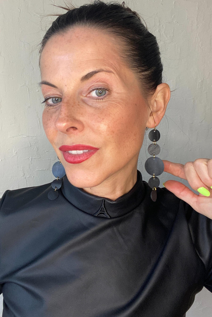 model wears upcycled bicycle inner tube earrings, black disc jewellery