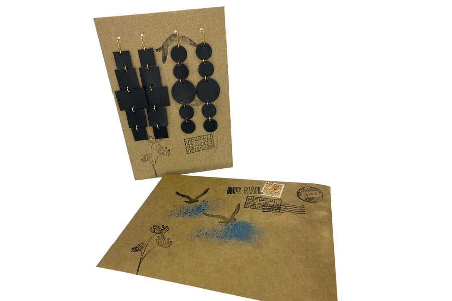 2 pairs of black golden upcycled bicycle inner tube, geometric earrings on a carton paper  display with matching gift envelope and black  background