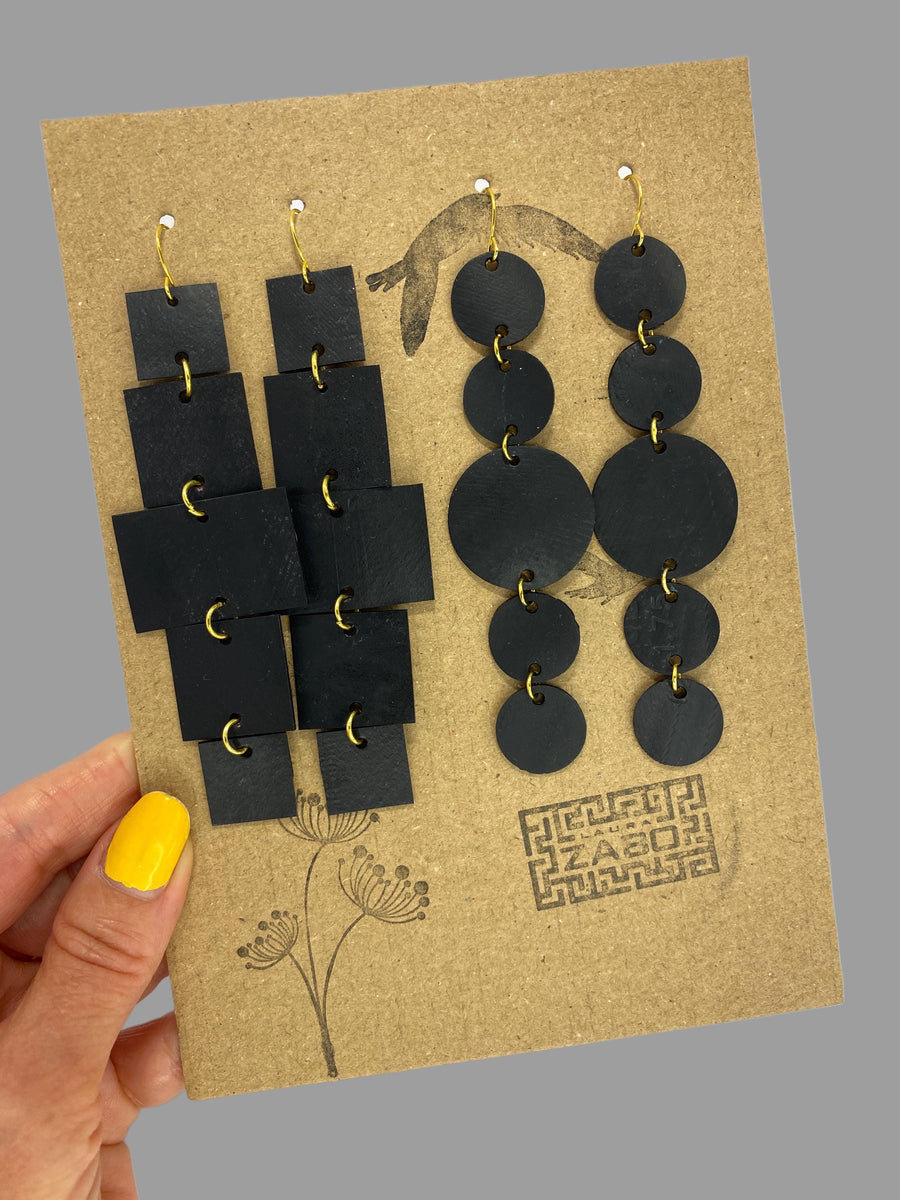 2 pairs of black golden upcycled bicycle inner tube, geometric earrings on a carton paper  display and grey background