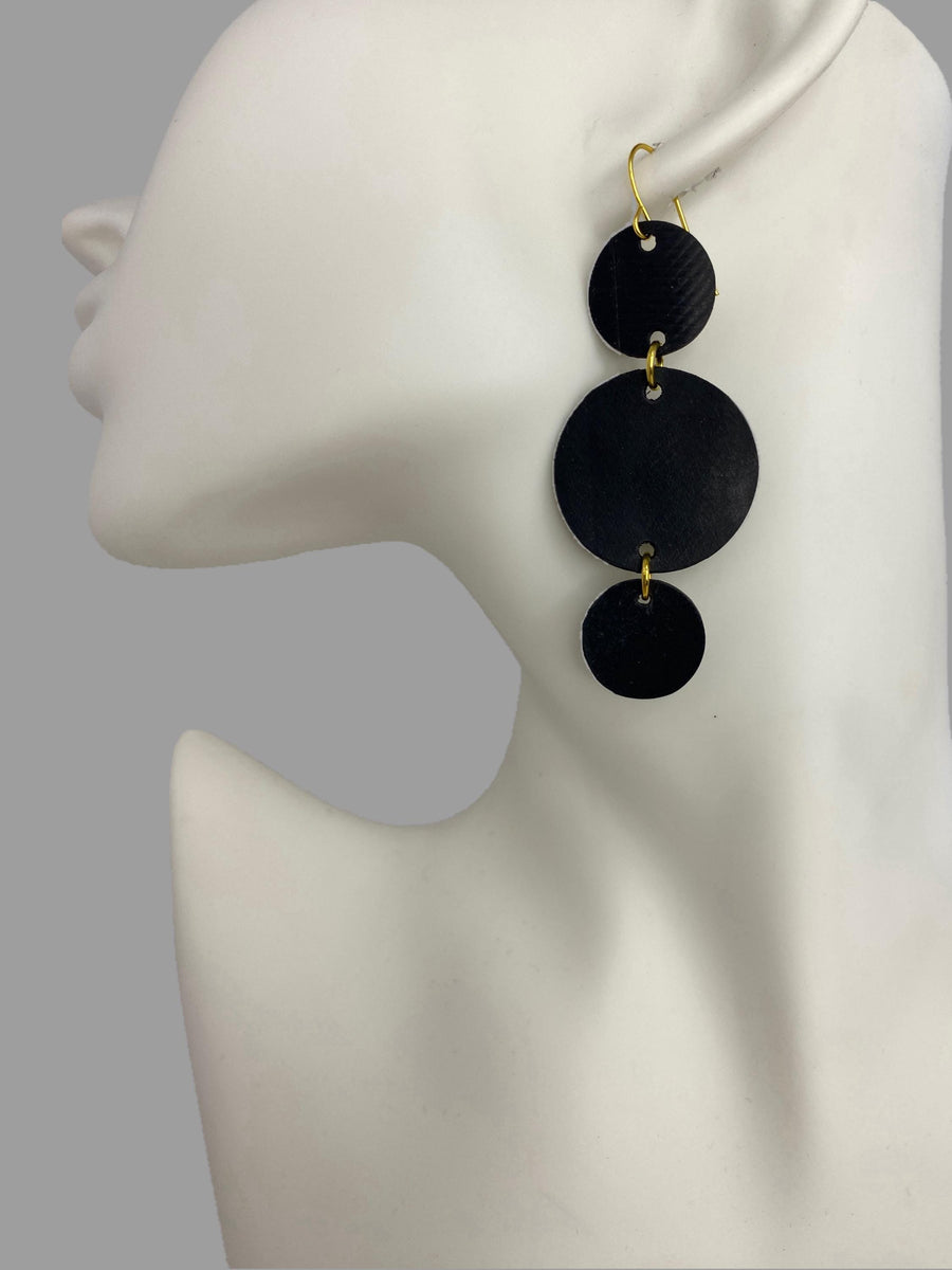 bicycle inner tube, black-golden, geometric, disc earrings on a white mannequin