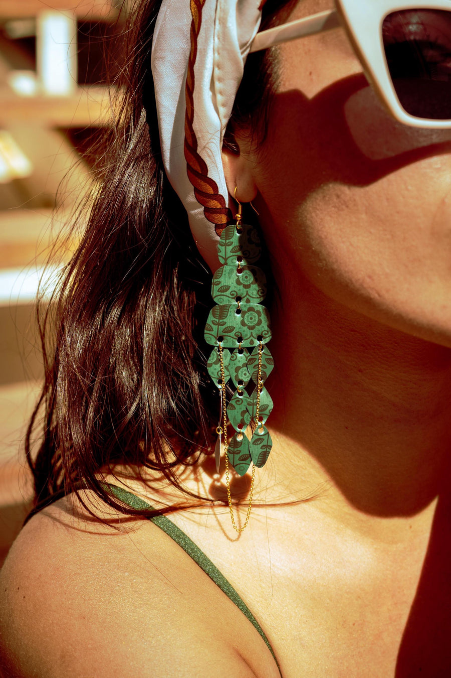 model wears dark green long chandelier earrings made from upcycled nespresso capsules