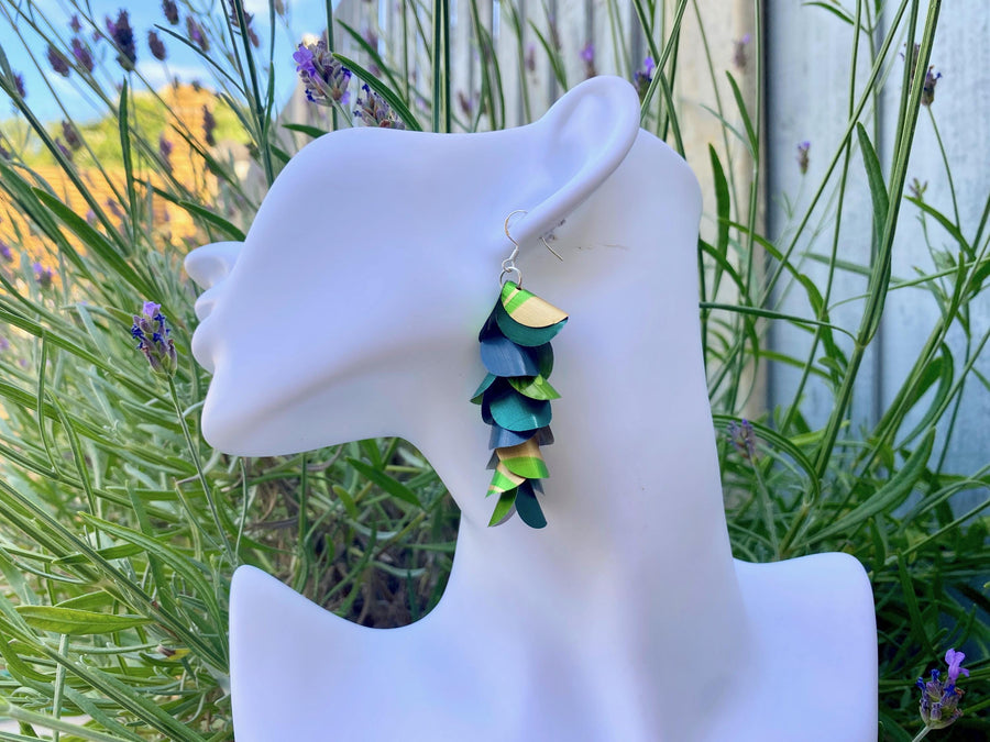 green golden cascading earrings made from upcycled nespresso pods on a white mannequin head