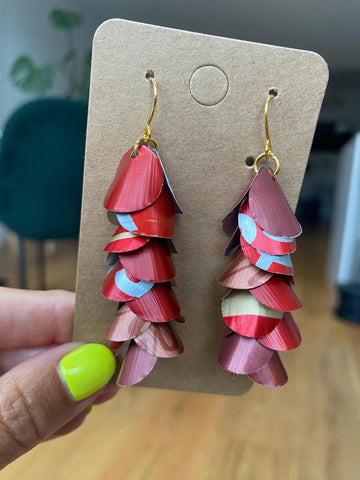 shades of red cascading earrings made from upcycled nespresso capsules on a paper display