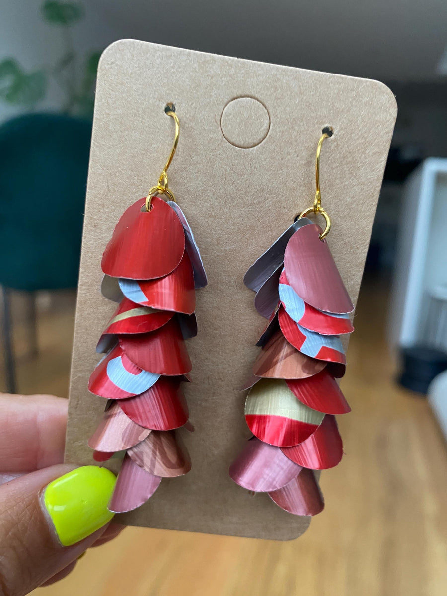 shades of red cascading earrings made from upcycled nespresso capsules on a paper display