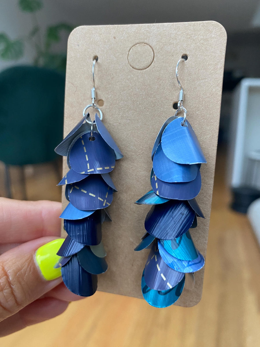 shades of blue, cascading earrings made from Nespresso capsules on a paper display