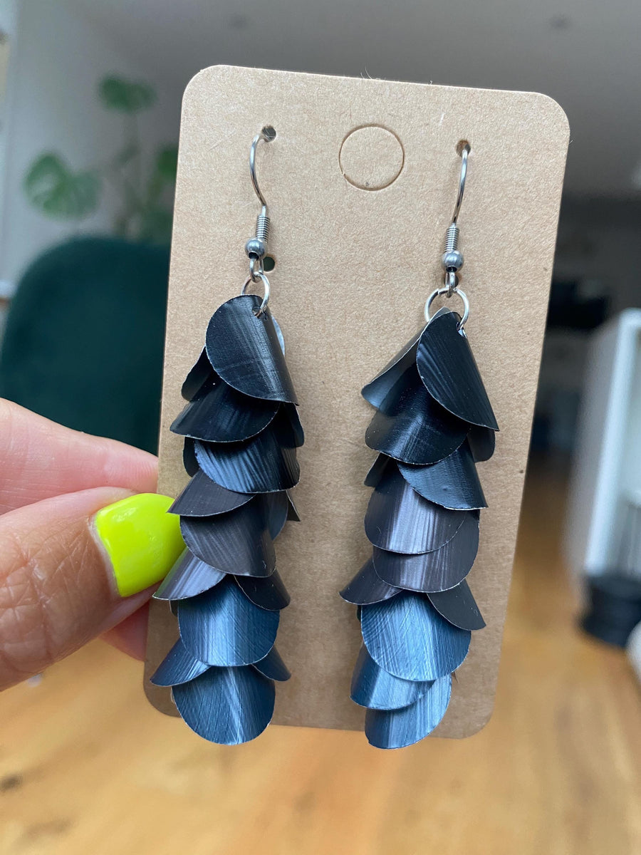 black grey cascading earrings made from upcycled nespresso pods on a paper display