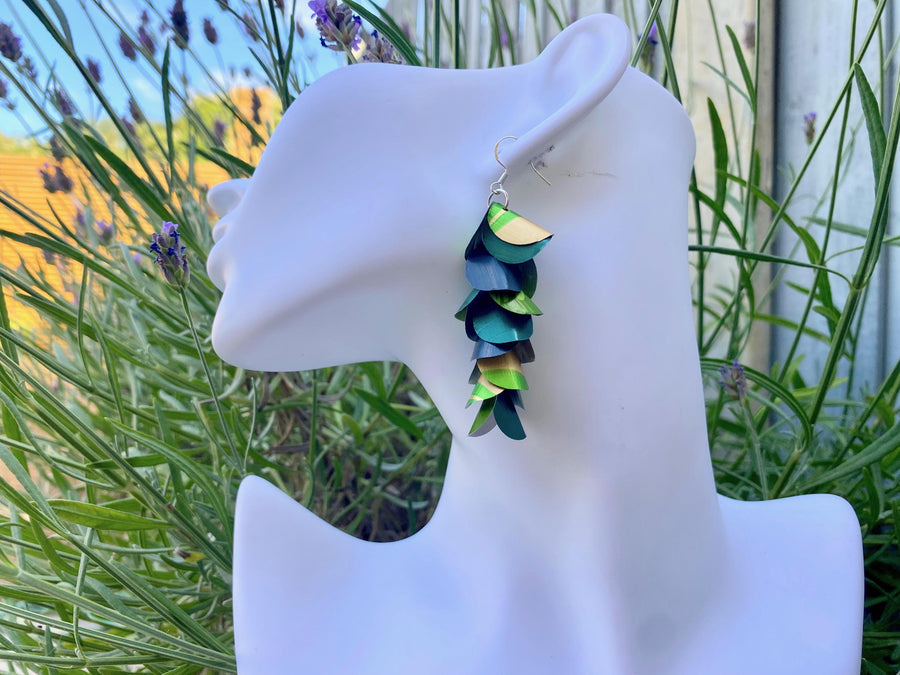green golden cascading earrings made from upcycled nespresso pods on a white mannequin head