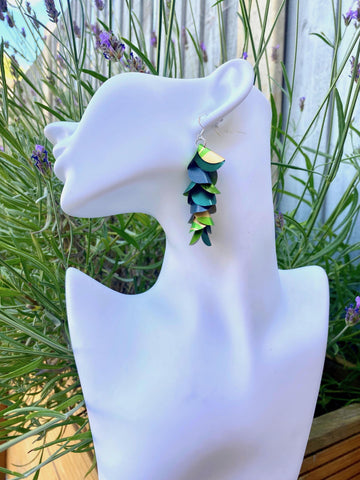 green golden cascading earrings made from upcycled nespresso pods on a white mannequin head