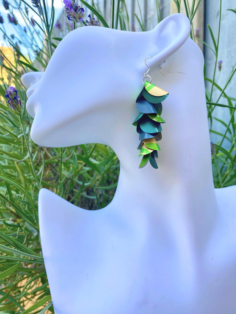 green golden cascading earrings made from upcycled nespresso pods on a white mannequin head