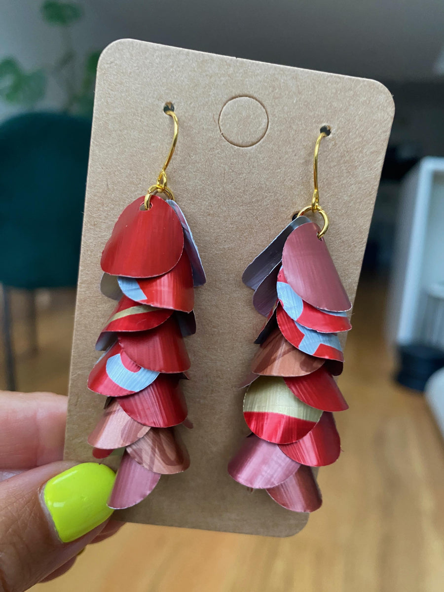 shades of red cascading earrings made from upcycled nespresso capsules on a paper display