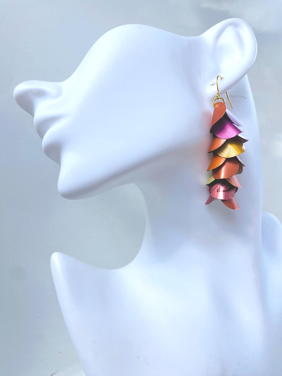 peach, orange, gold cascading earrings made from nespresso capsules on a white mannequin head