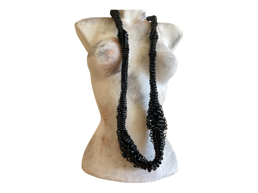 very bold, black scultural necklace made from upcycled bicycle inner tube strips on a mannequin