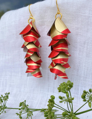 red gold upcycled earrings made from nespresso capsules aluminium on a white linen background and a green flower