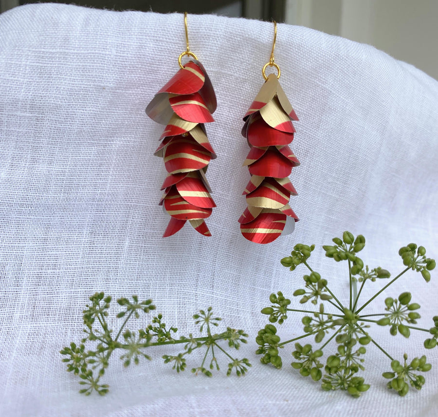 red gold upcycled earrings made from nespresso capsules aluminium on a white linen background and a green flower
