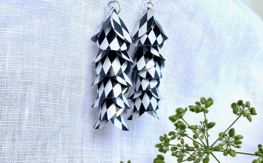 black white cascade earrings made from upcycled nespresso capsule aluminium on a white linen background and green plant