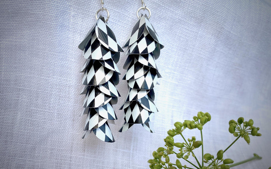 black white cascade earrings made from upcycled nespresso capsule aluminium on a white linen background and green plant
