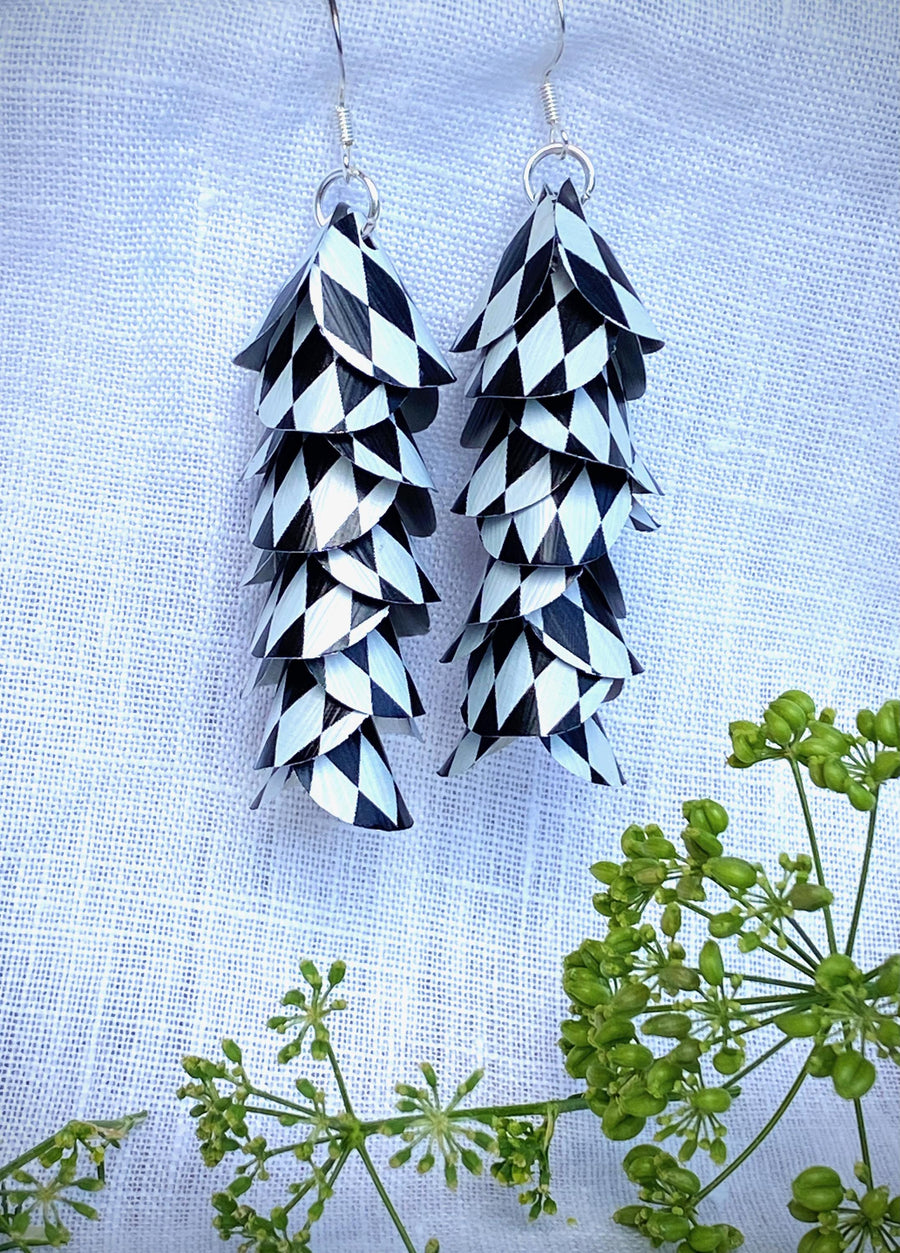 black white cascade earrings made from upcycled nespresso capsule aluminium on a white linen background and green plant