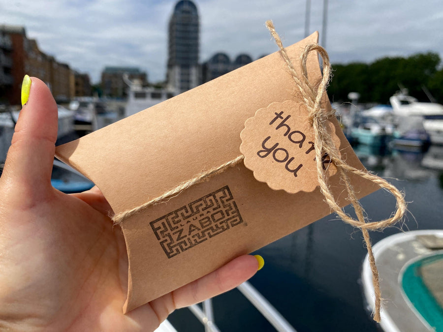 brown, gift pillow packaging with laura zabo logo in hand