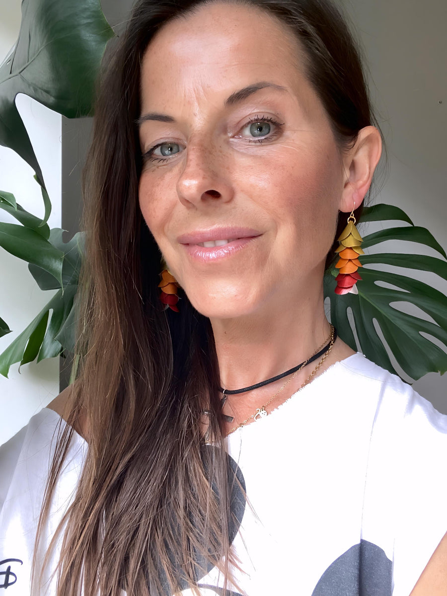 model wears sunset, sunrise themed gold-orange-red earrings made from upcycled nespresso pod aluminium